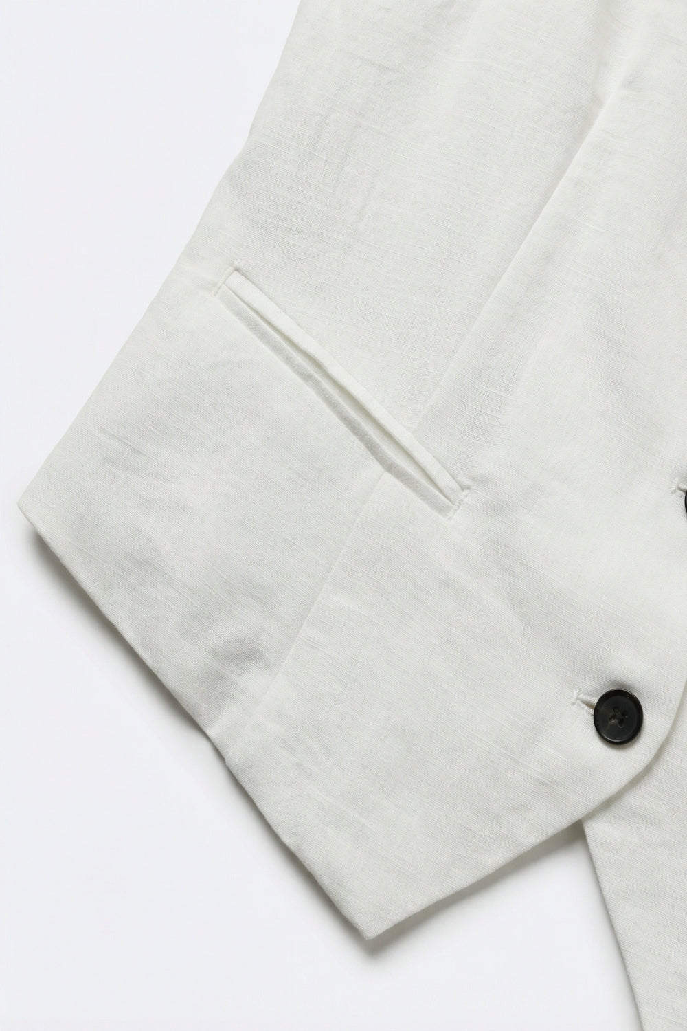 Gilet blanc texturé avec boutons noirs sur le devant