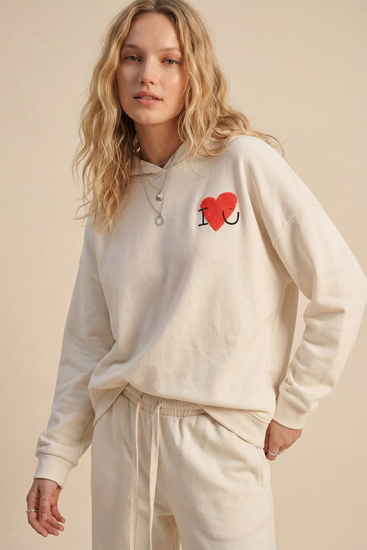 Chandail à capuchon super doux de couleur crème avec graphique en forme de cœur bouclé