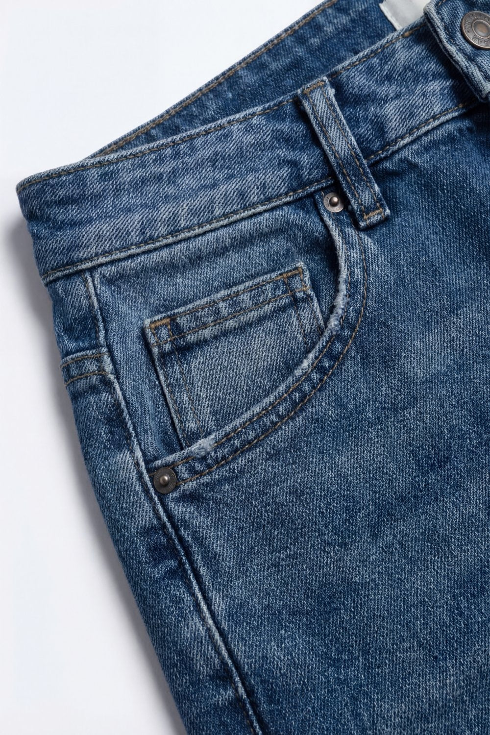 Jeans en denim bleu à jambe large et délavage léger avec revers