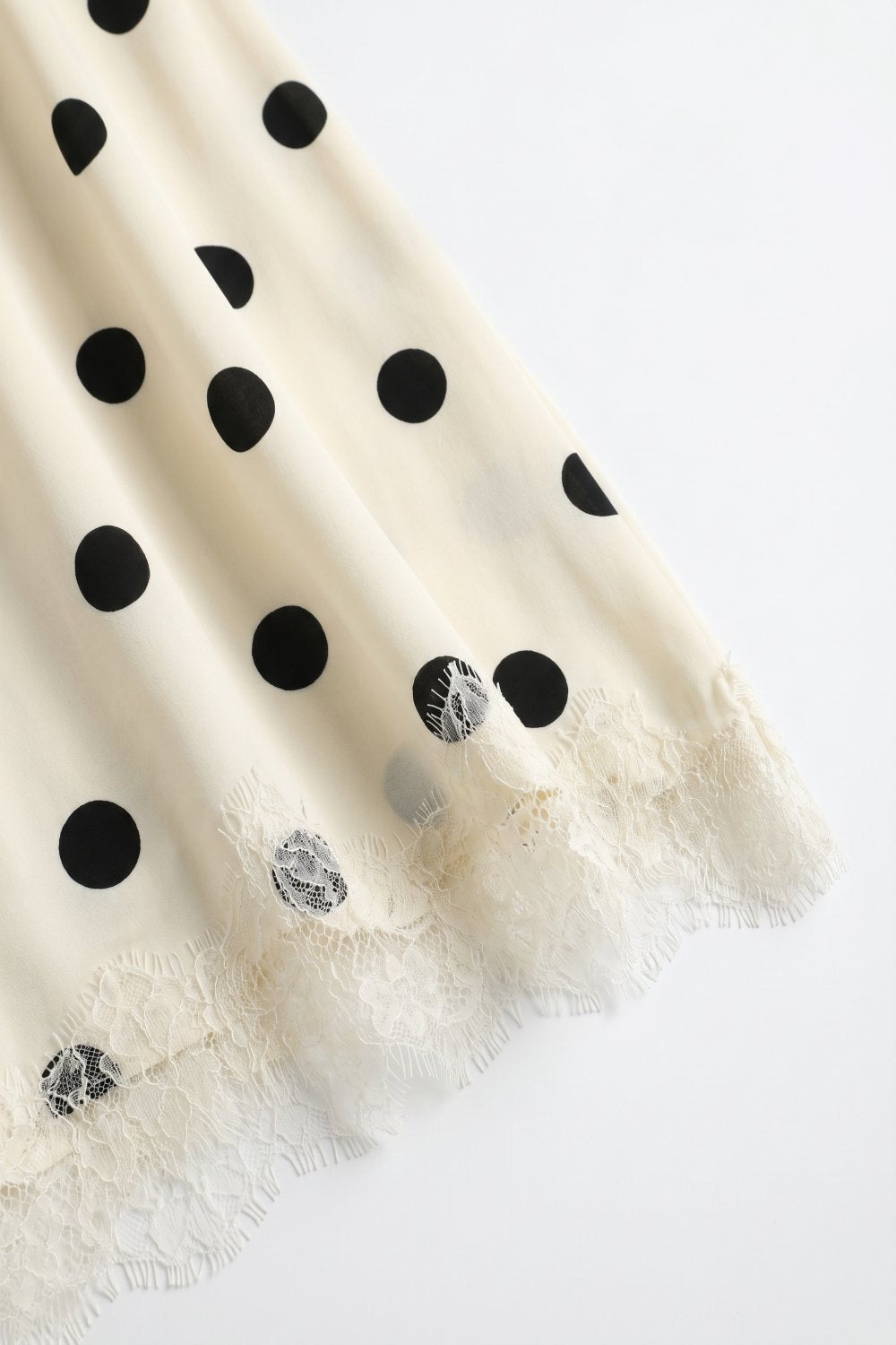 Jupe midi asymétrique en satin imprimé pois crème avec bordures en dentelle