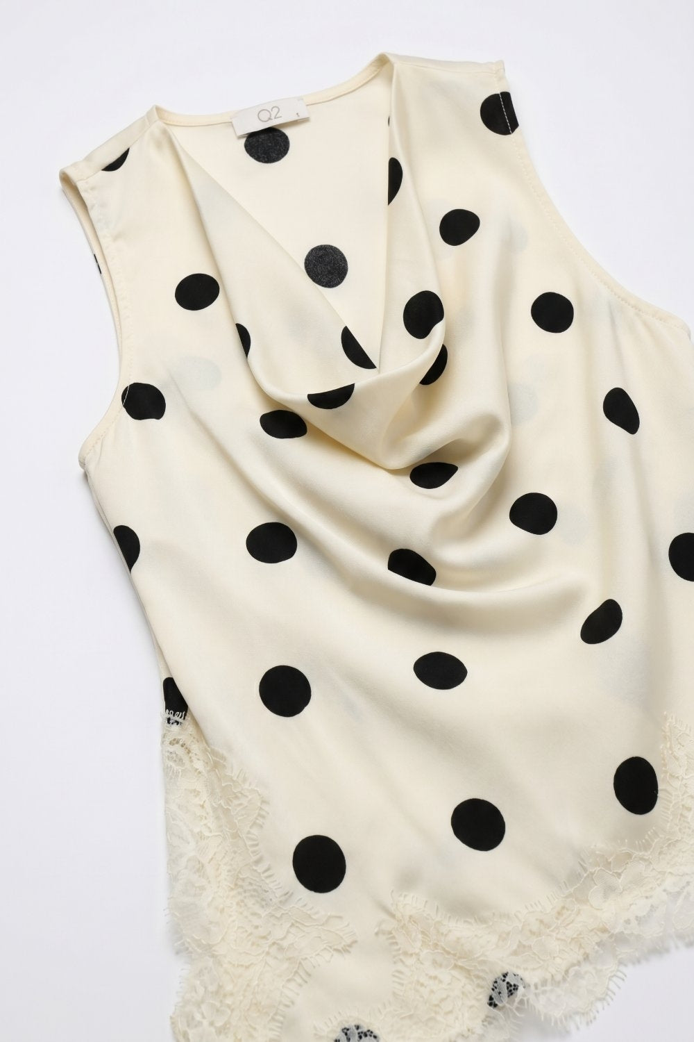 Top asymétrique sans manches en satin à pois crème bordé de dentelle