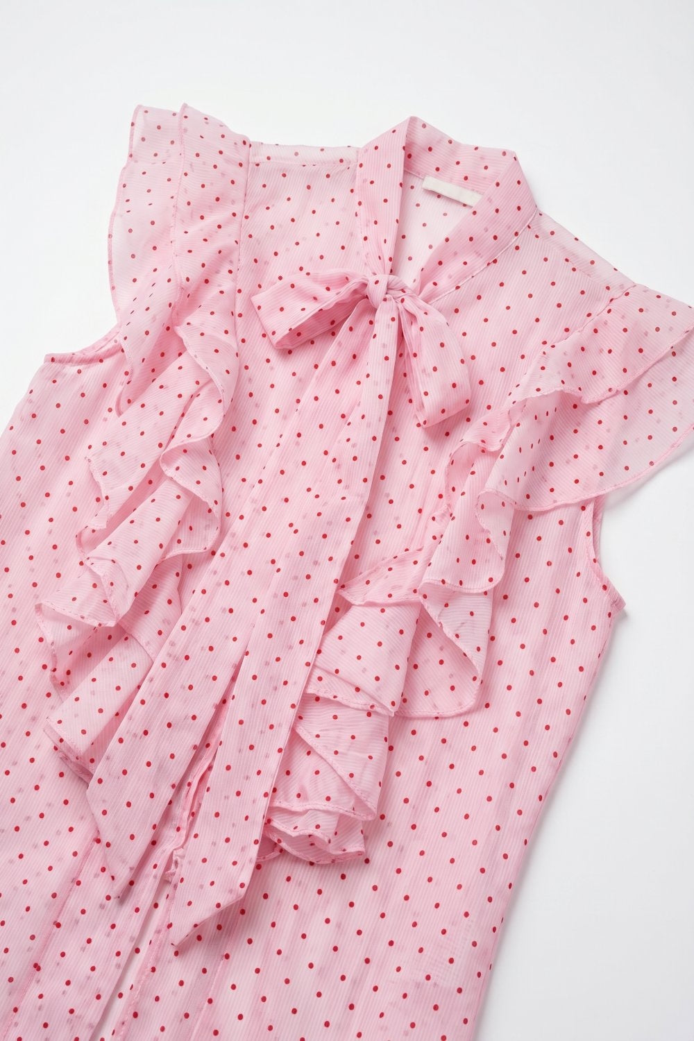 Blouse sans manches en mousseline rose clair à pois avec volants et nœud papillon