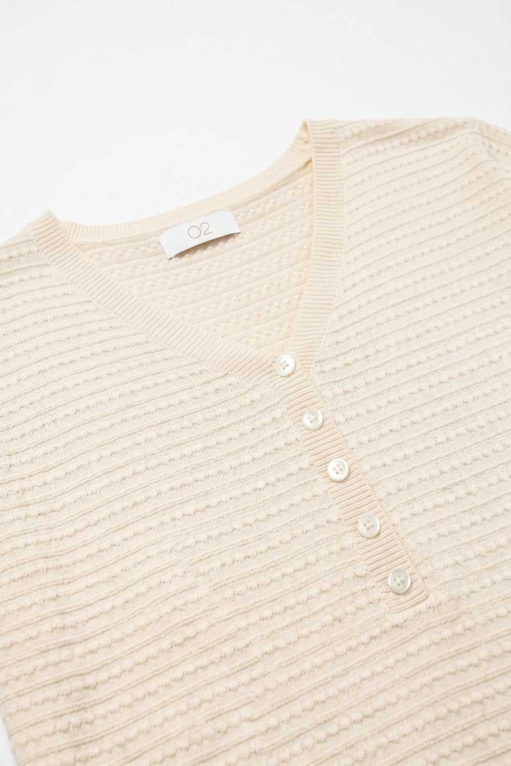 Pull à manches courtes en maille fine texturée avec détails de boutons en beige