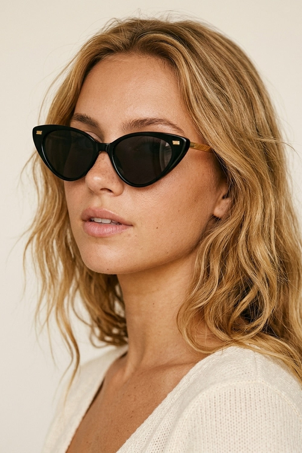 Lunettes de soleil noires à monture brillante et détails dorés en œil de chat