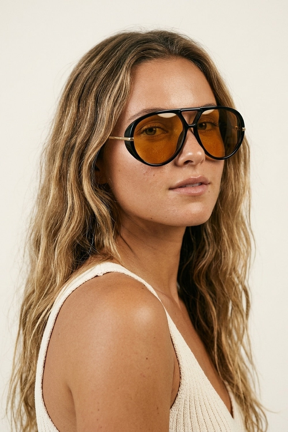 Lunettes de soleil noires à monture aviateur oversize avec bordure dorée et verres ambrés