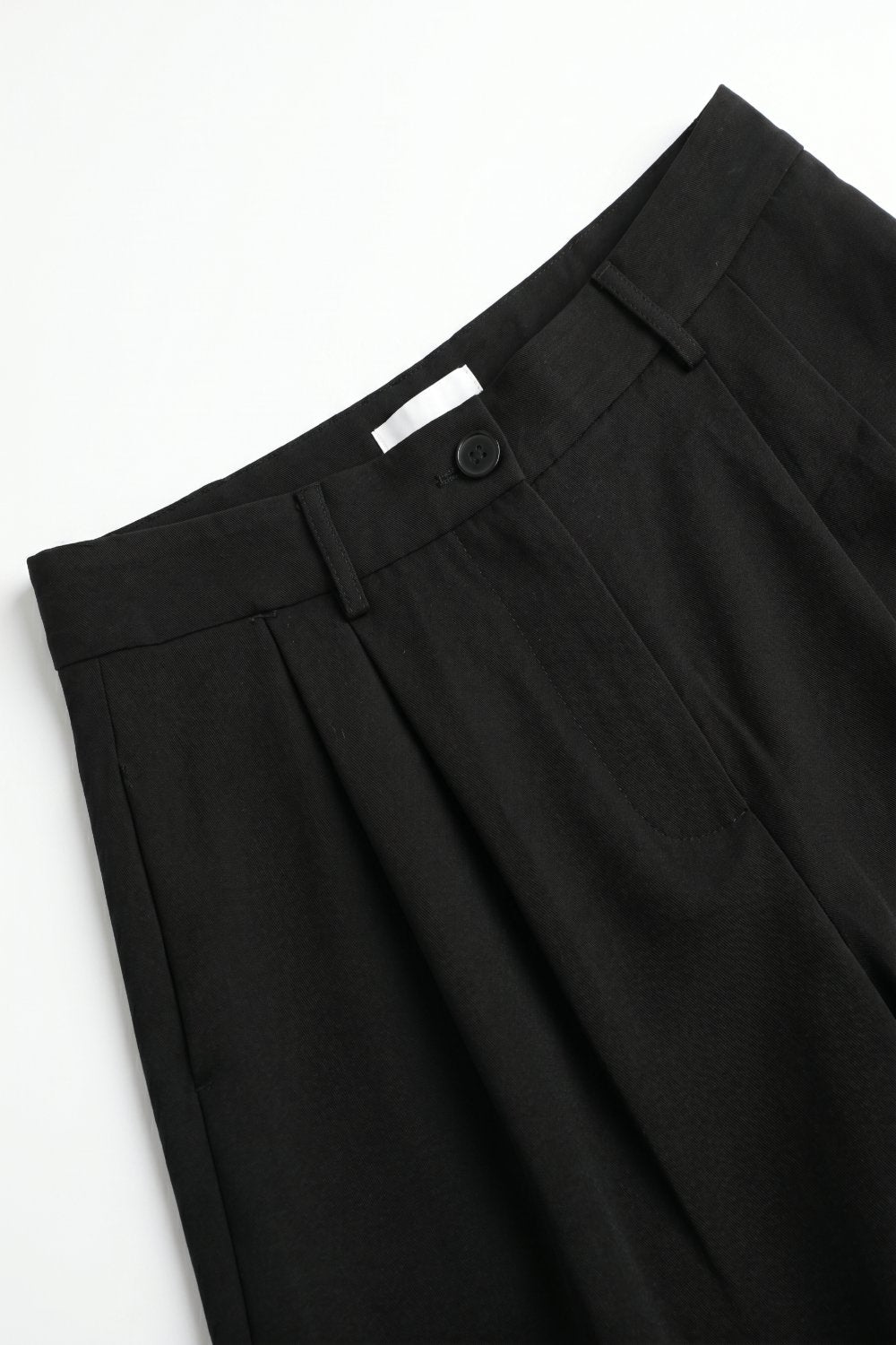 Bermuda noire plissée avec longueur au genou et coupe ajustée