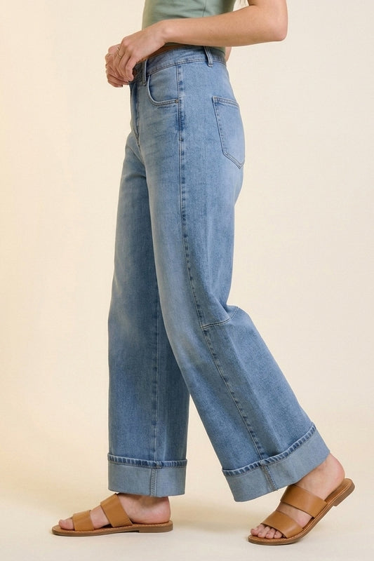 Jeans en denim bleu à jambe large et délavage léger avec revers