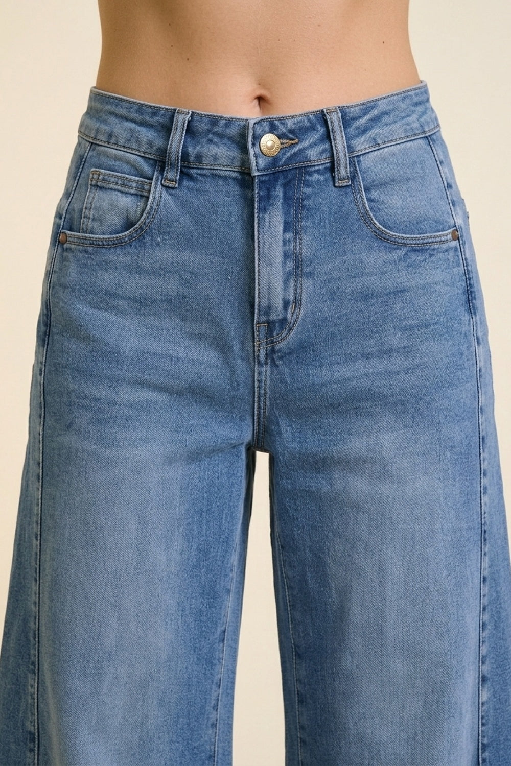 Jeans en denim bleu à jambe large et délavage léger avec revers