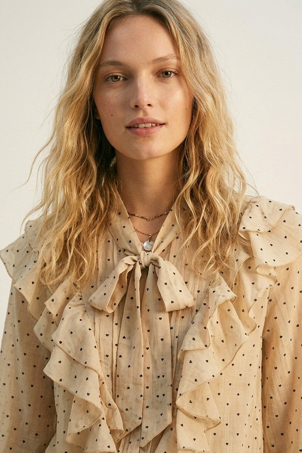 Blouse beige à pois à volants avec col à nouer