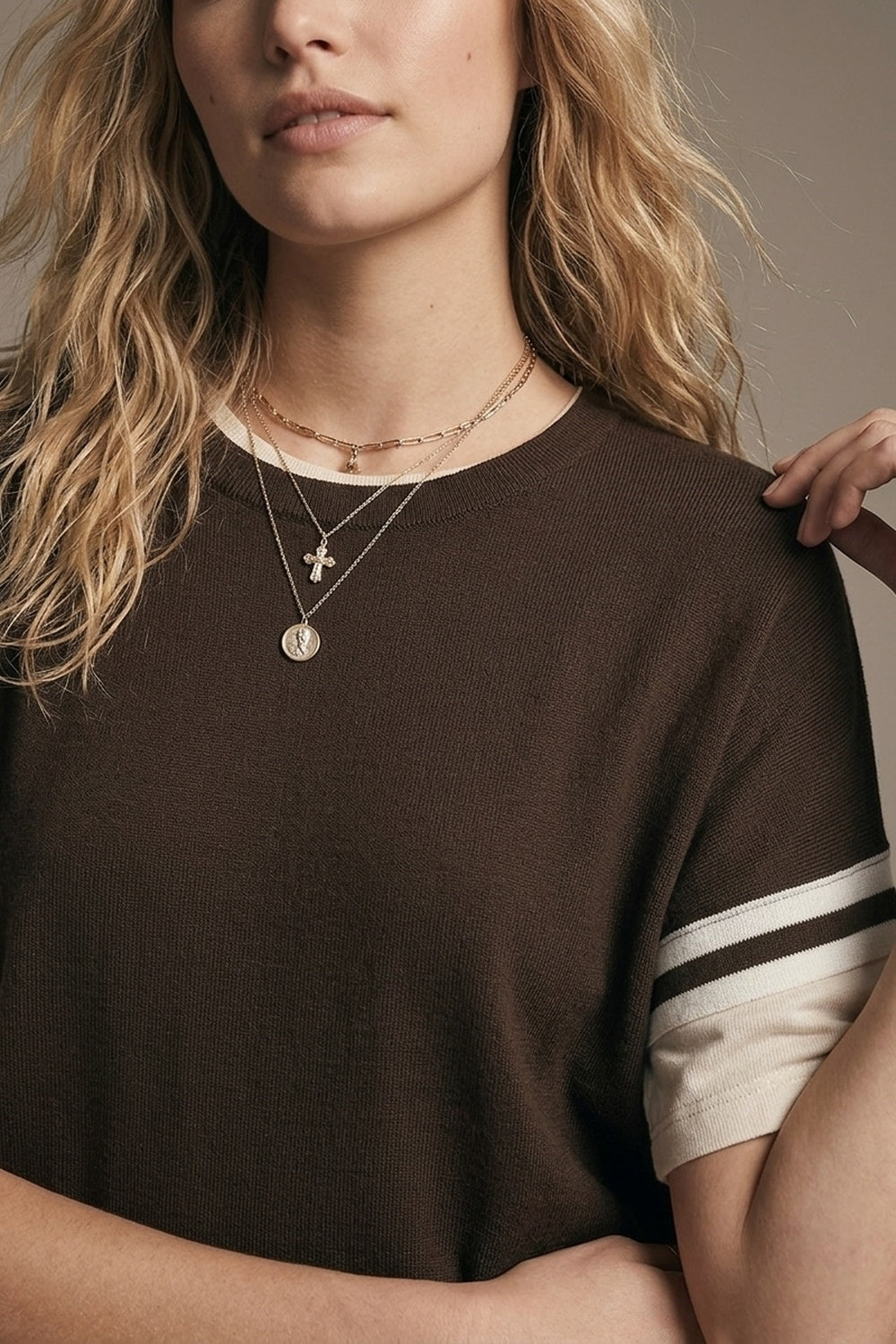 Pull en tricot marron avec détail de manche à rayure blanche