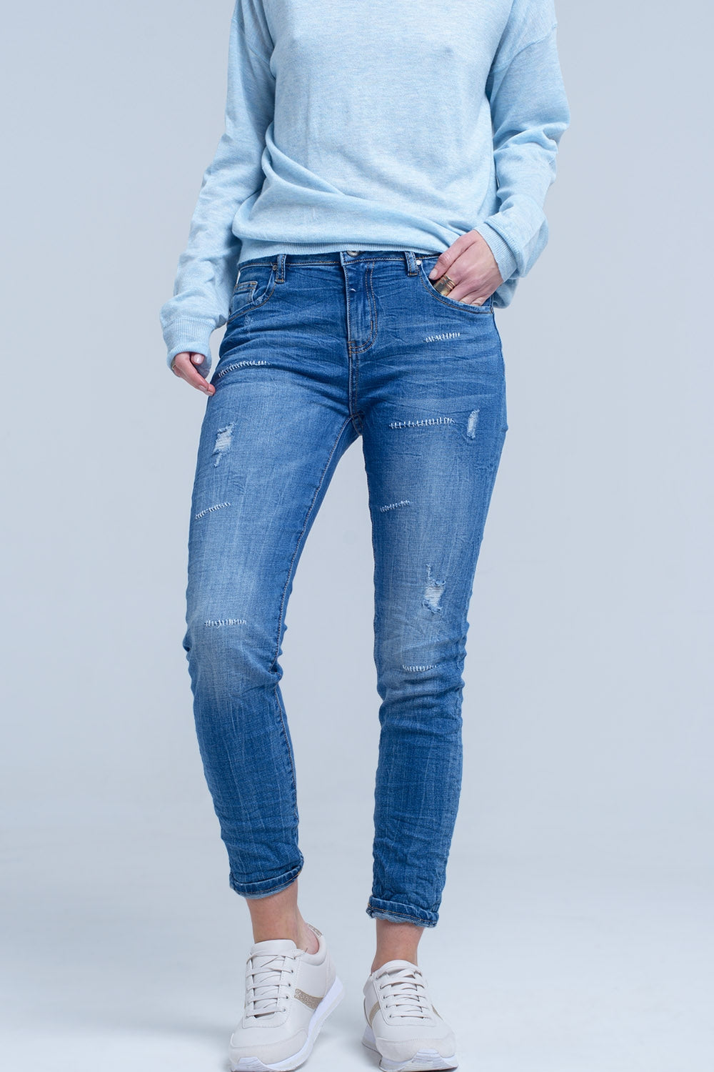 Jeans à la cheville avec déchirure et réparation