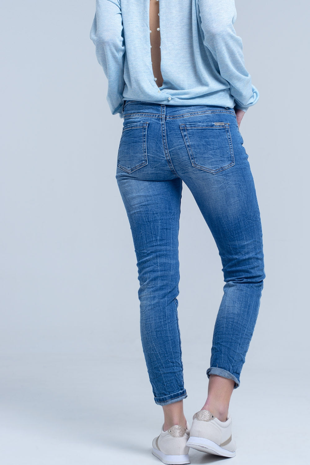 Jeans à la cheville avec déchirure et réparation