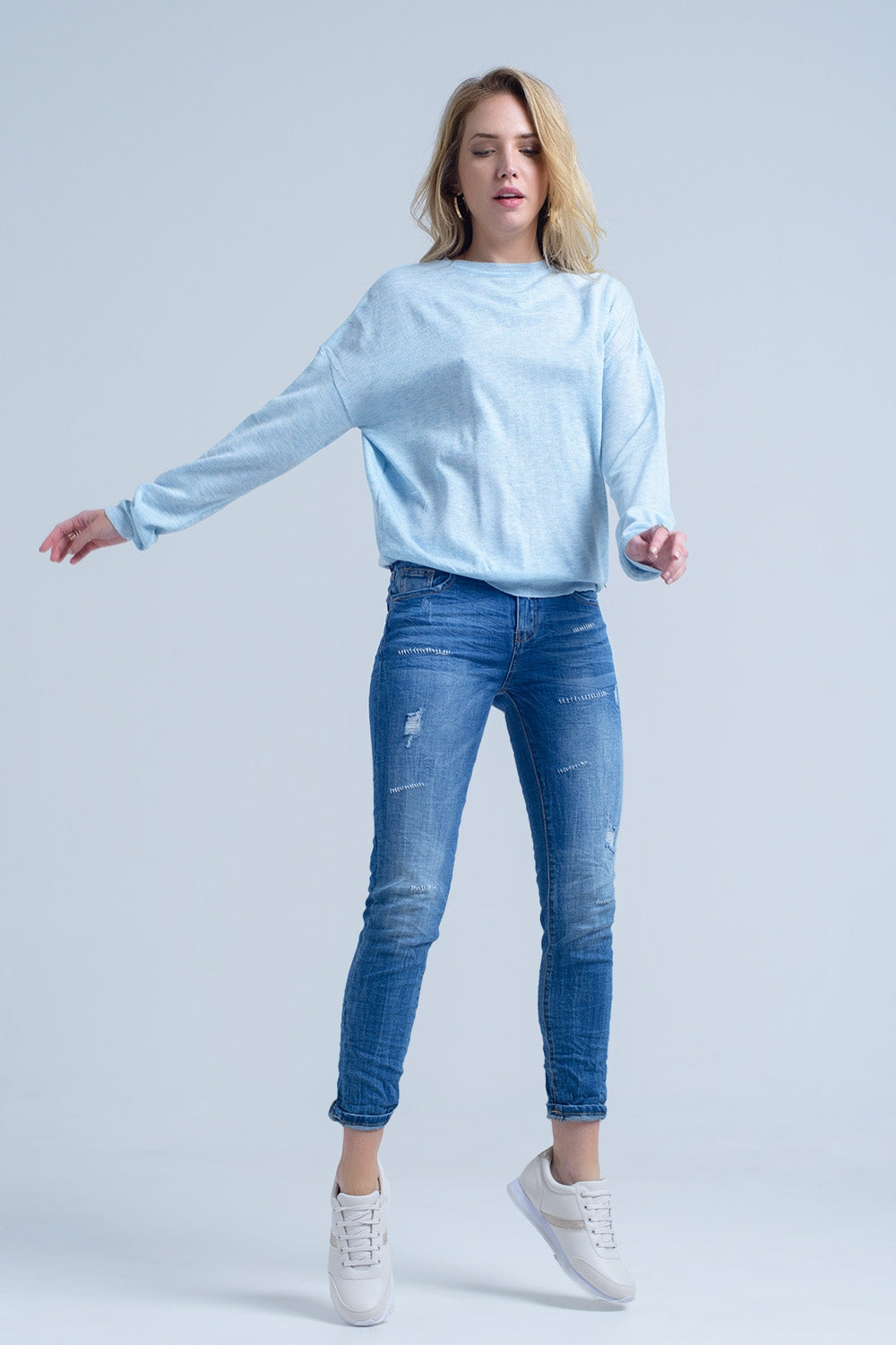 Jeans à la cheville avec déchirure et réparation