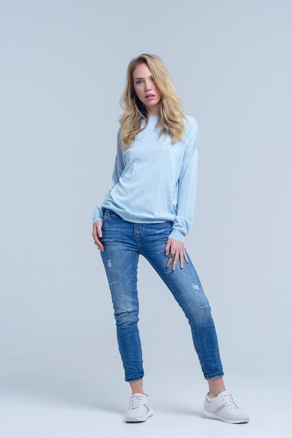 Jeans à la cheville avec déchirure et réparation