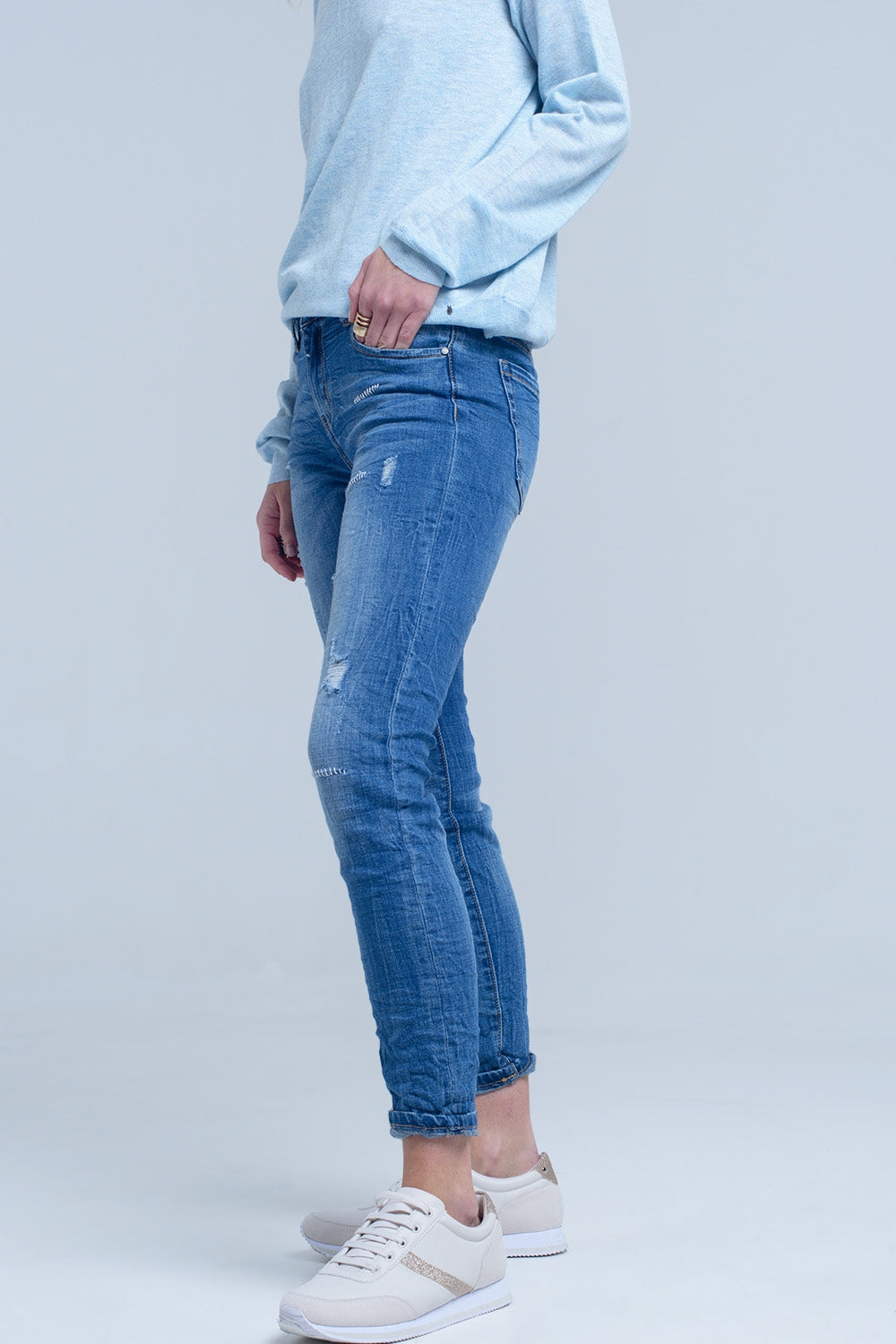 Jeans à la cheville avec déchirure et réparation