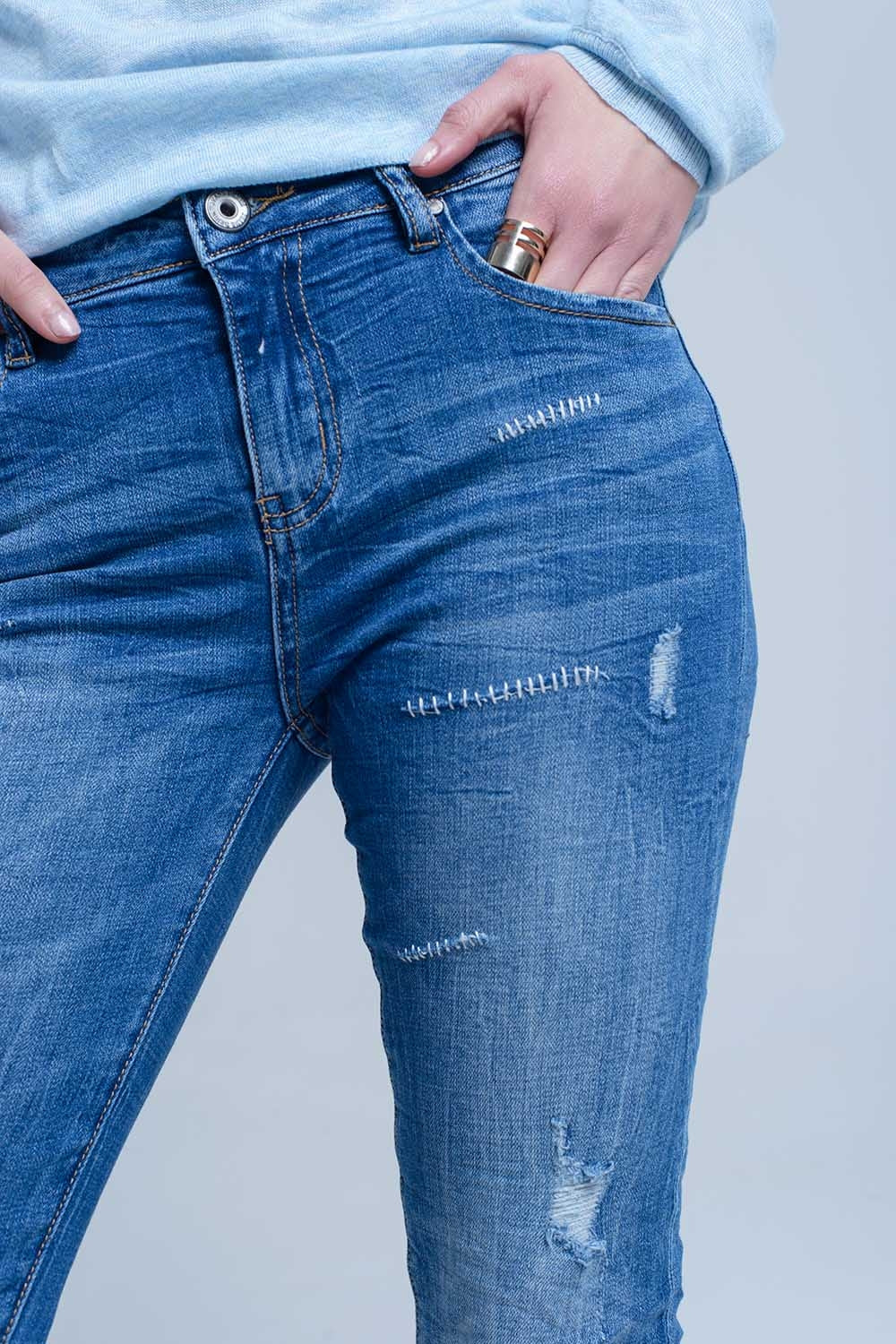 Jeans à la cheville avec déchirure et réparation