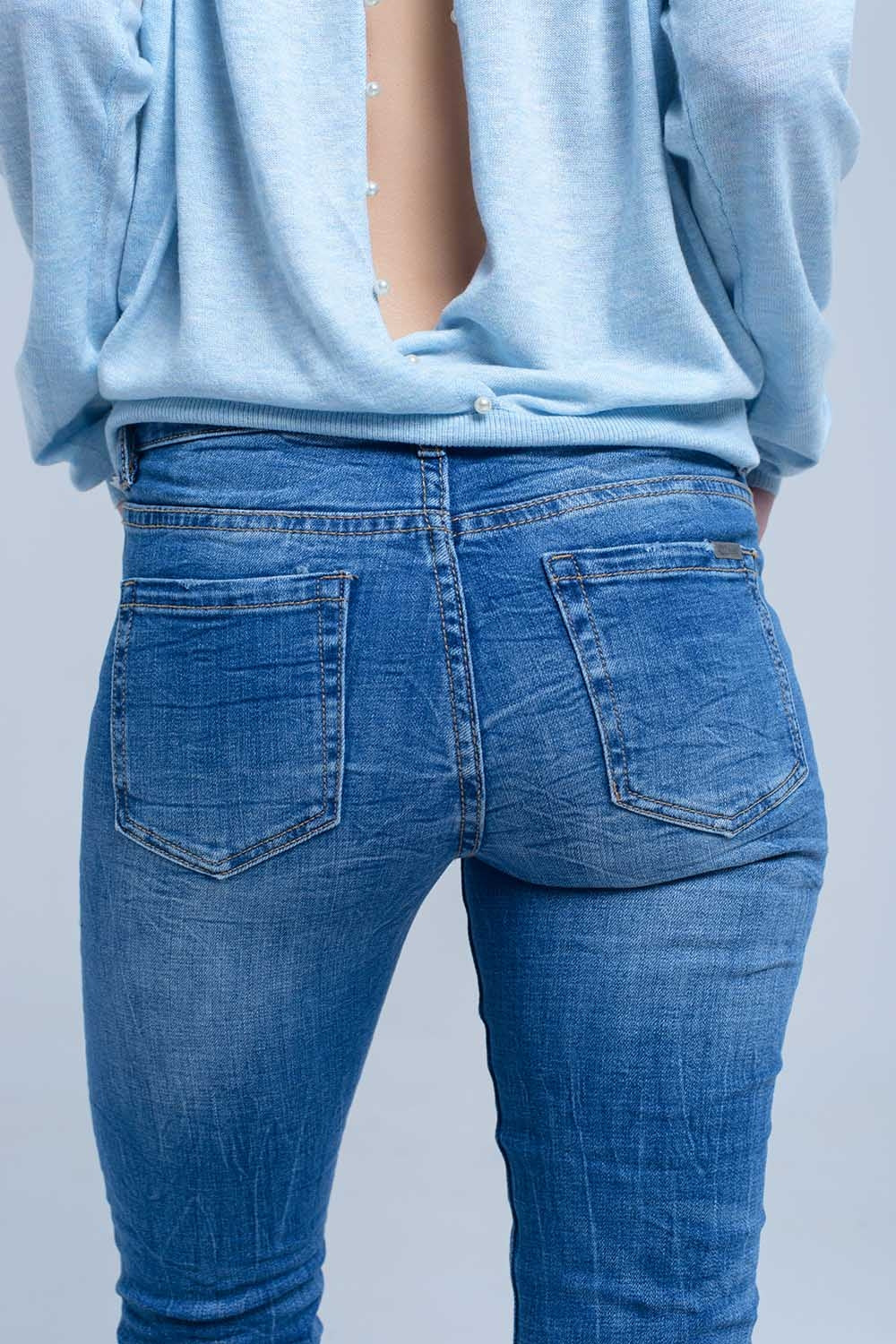 Jeans à la cheville avec déchirure et réparation