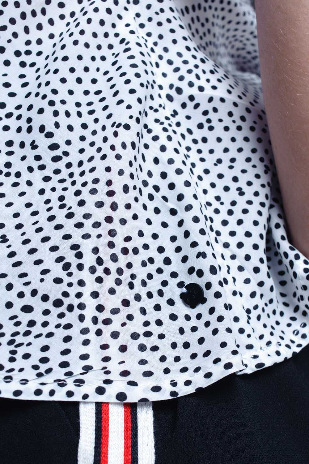 Top blanc à pois avec ourlet à volants