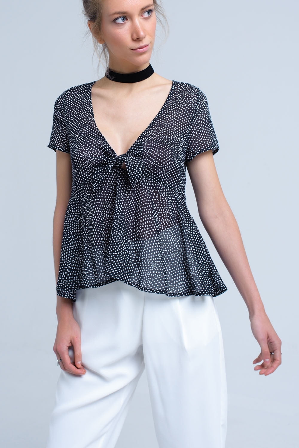 Top noir à pois avec ourlet à volants