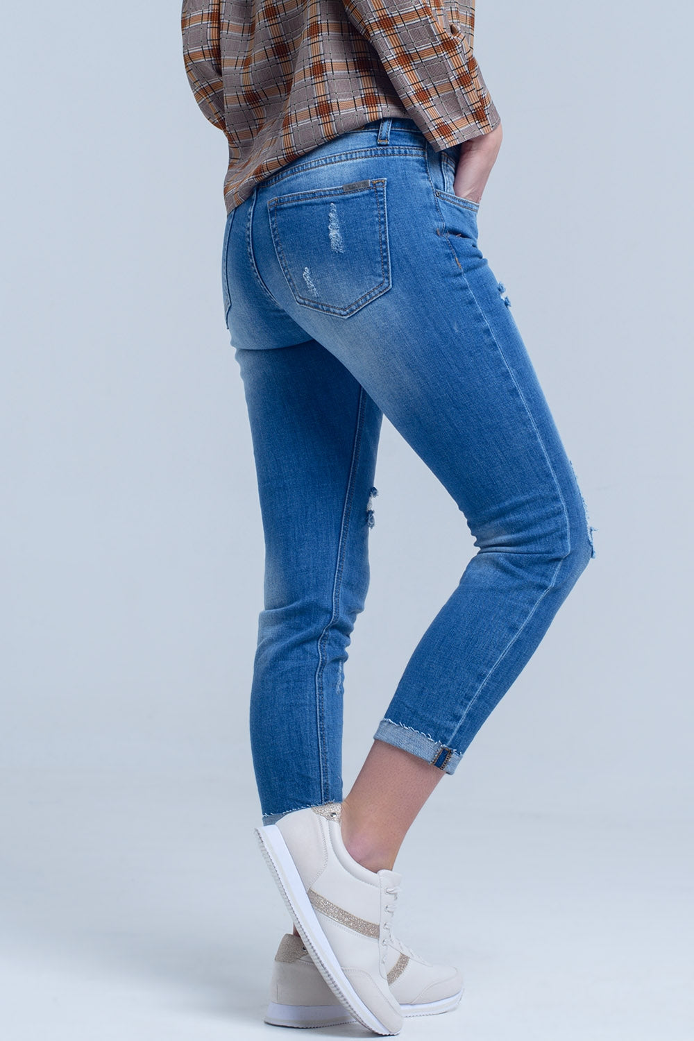 Jean maigre avec des déchirures sur les jambes