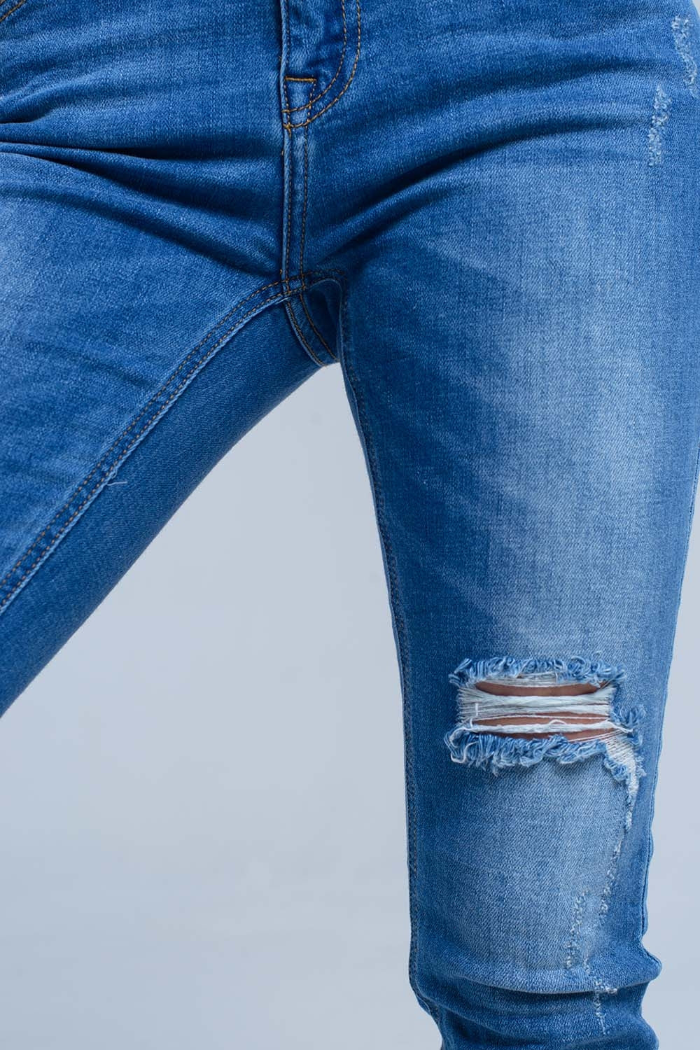 Jean maigre avec des déchirures sur les jambes