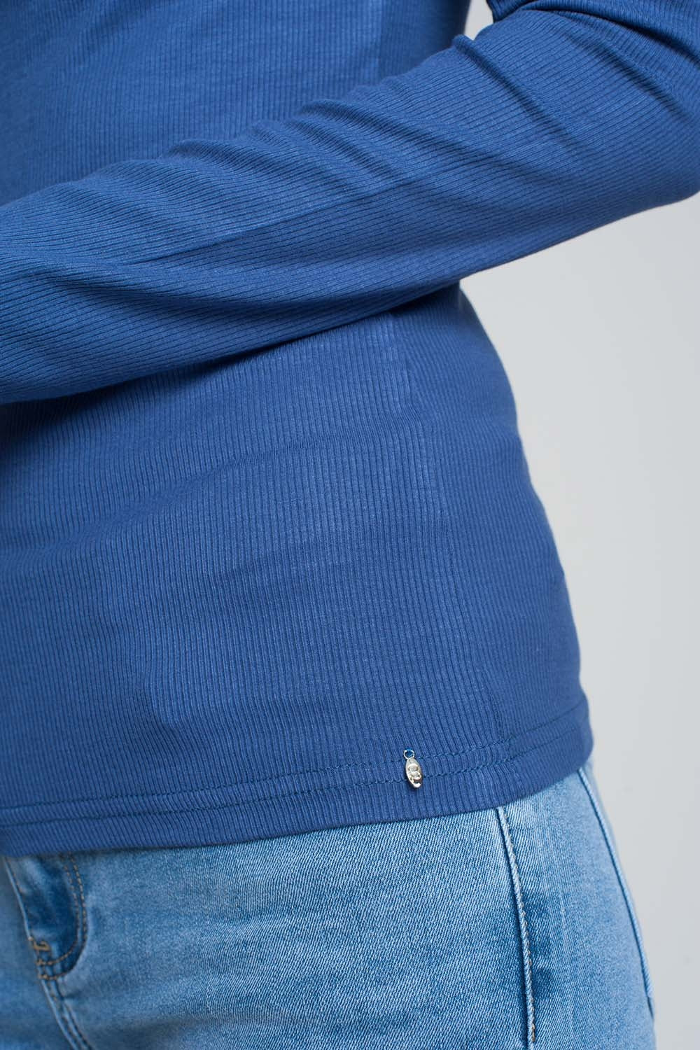 Pull bleu avec une épaule ouverte et un col montant