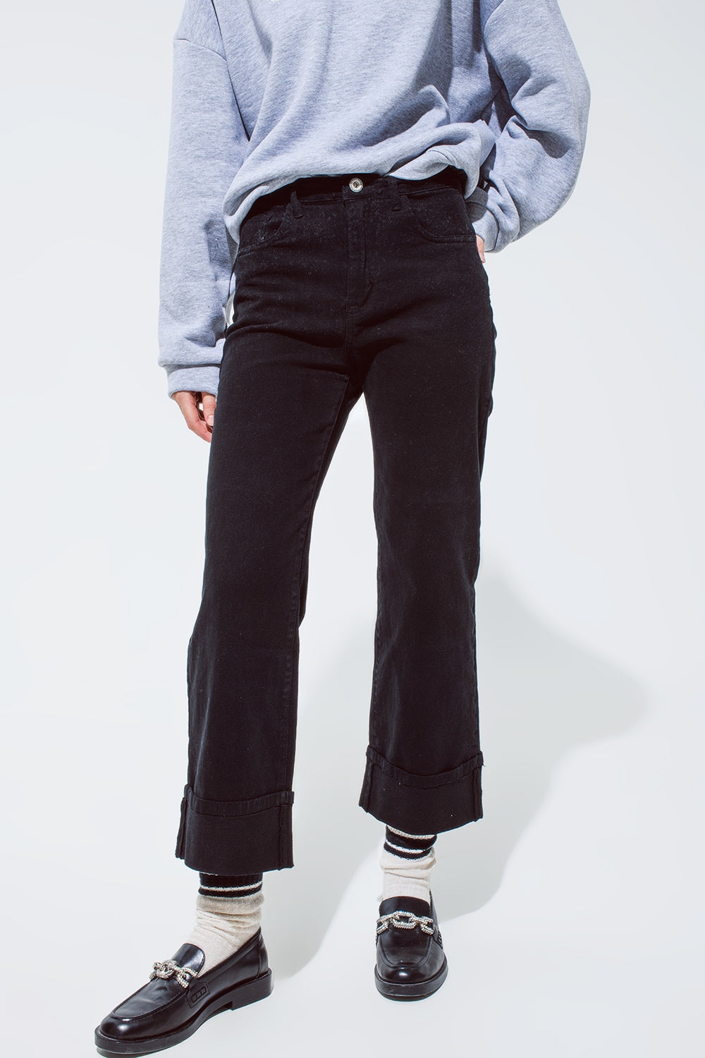 Jean droit noir avec les jambes repliées
