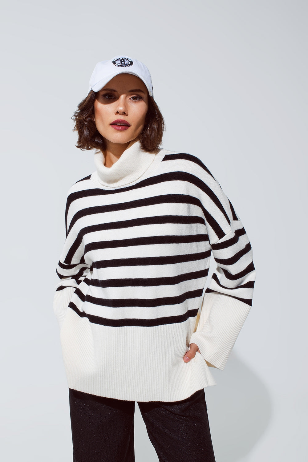 Pull blanc surdimensionné à col roulé avec des rayures noires et des fentes sur le côté