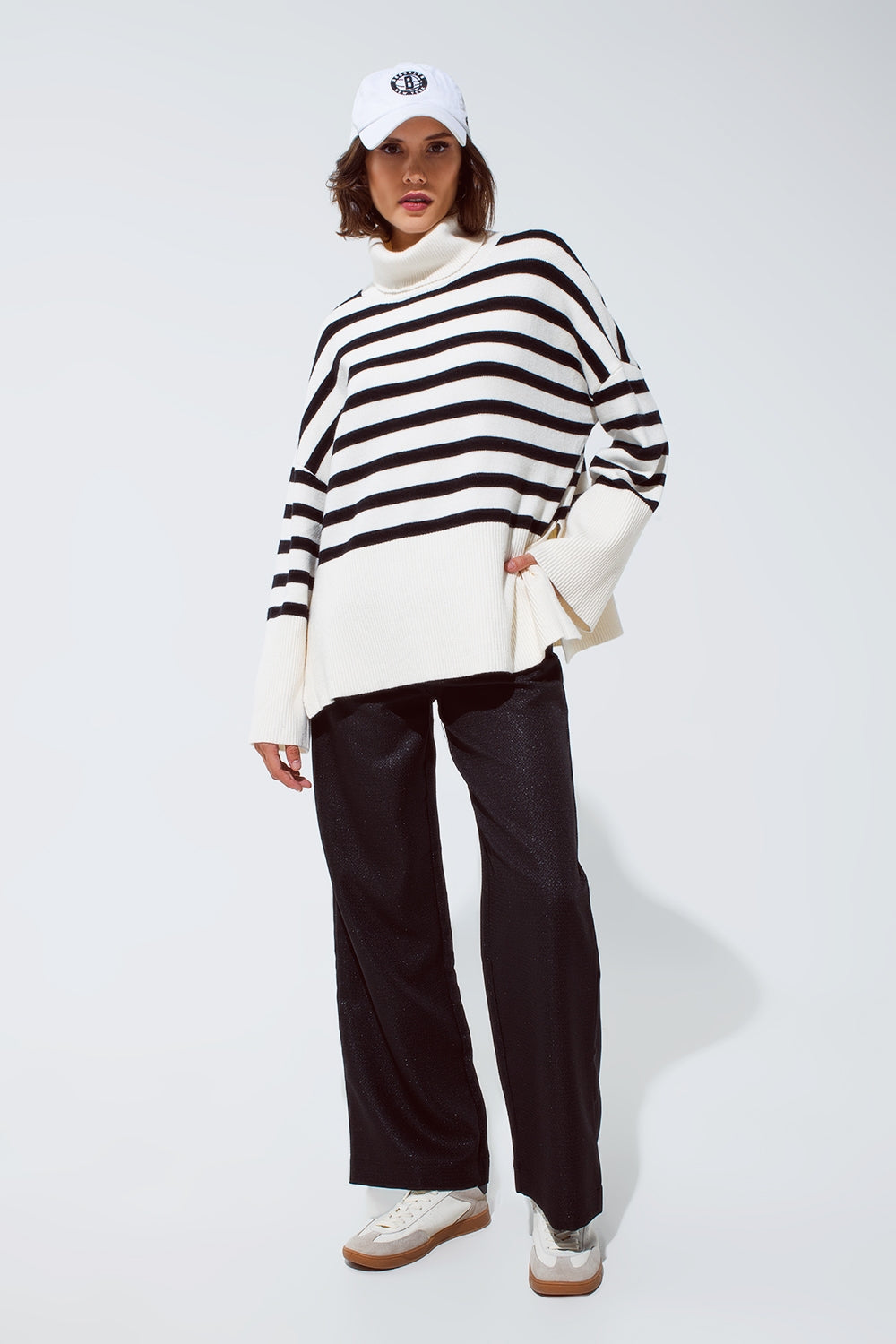 Pull blanc surdimensionné à col roulé avec des rayures noires et des fentes sur le côté