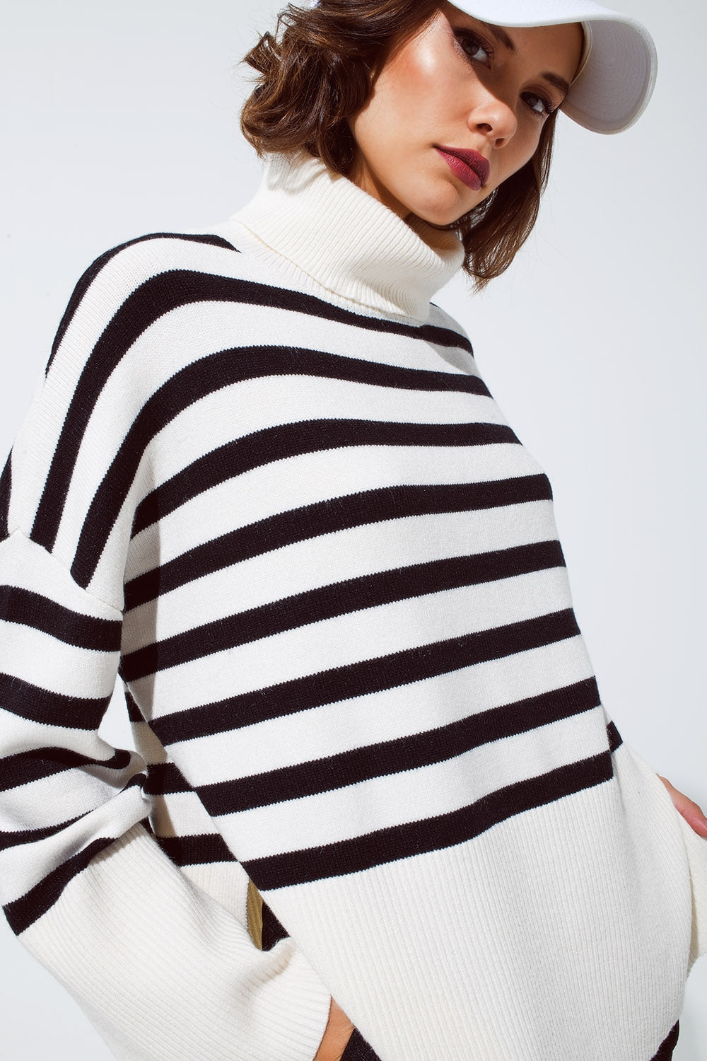 Pull blanc surdimensionné à col roulé avec des rayures noires et des fentes sur le côté