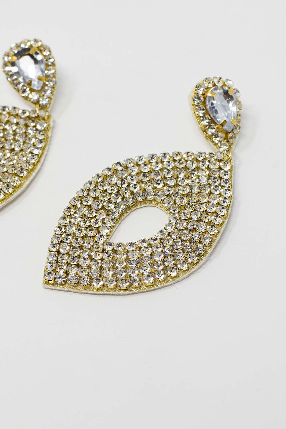 Longues boucles d'oreilles rhomboïdales avec un gros bijou central et des détails en strass