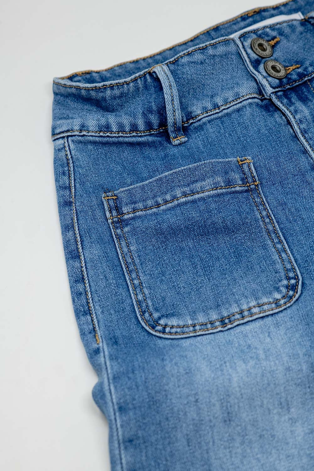 Jeans jambes larges avec fermeture frontale par boutons métalliques et poches frontales