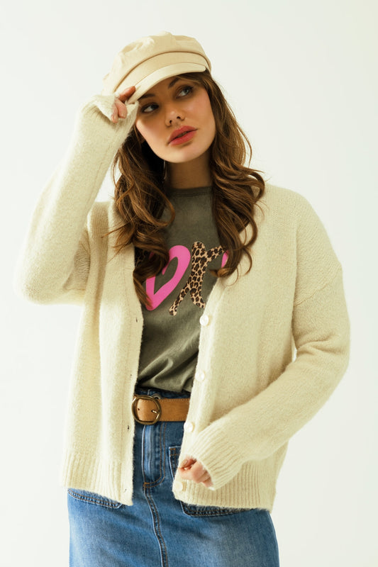 Cardigan à manches longues de couleur crème avec fermeture sur le devant par des boutons