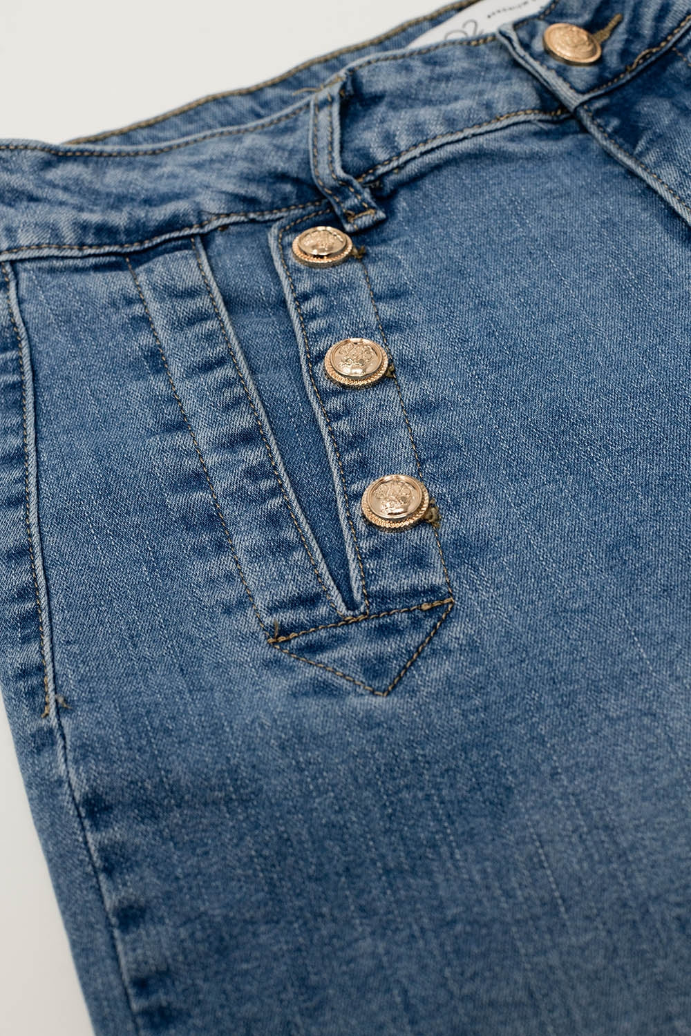 Jean droit évasé en bleu délavé avec détails de boutons