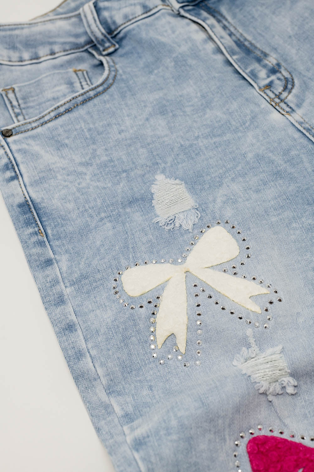 Jean super skinny bleu clair avec nœud papillon et trous déchirés
