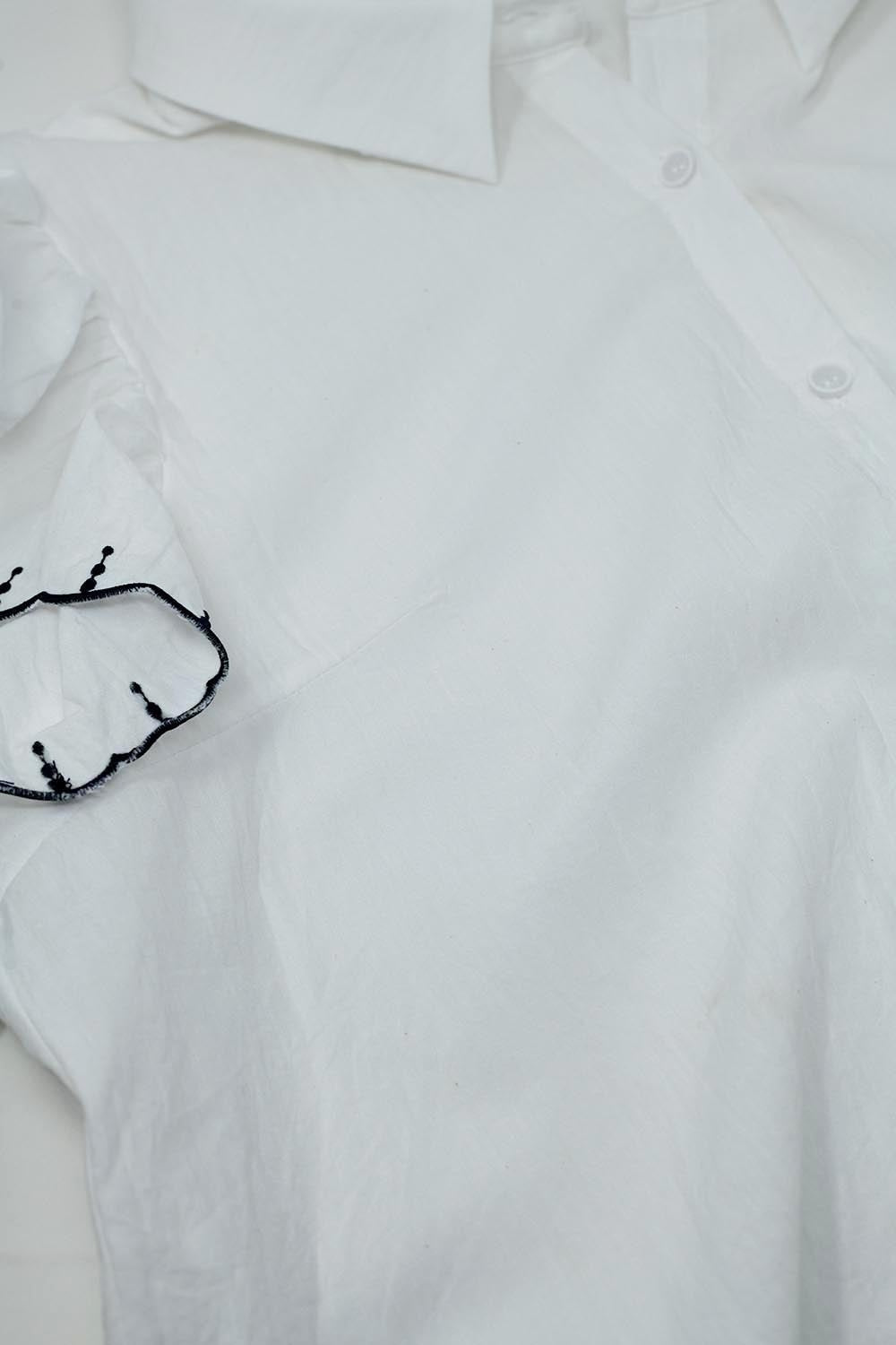 Chemise blanche à boutons avec col polo et manches à volants avec bordures noires