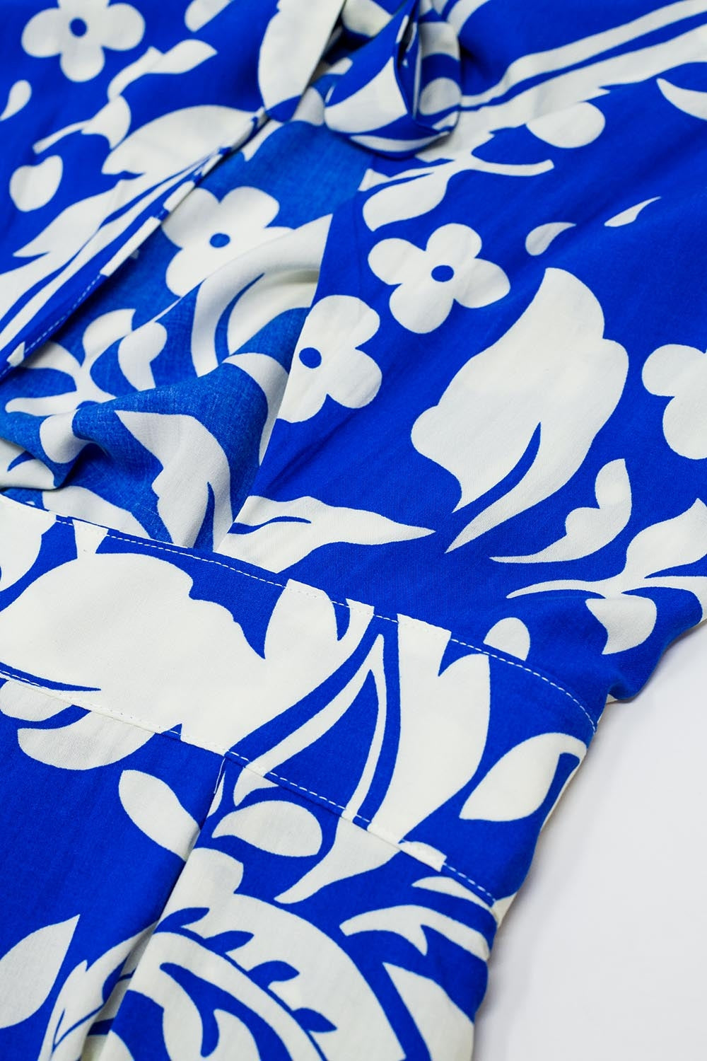 Combinaison à manches courtes avec trou de serrure sur le devant et motifs floraux en bleu