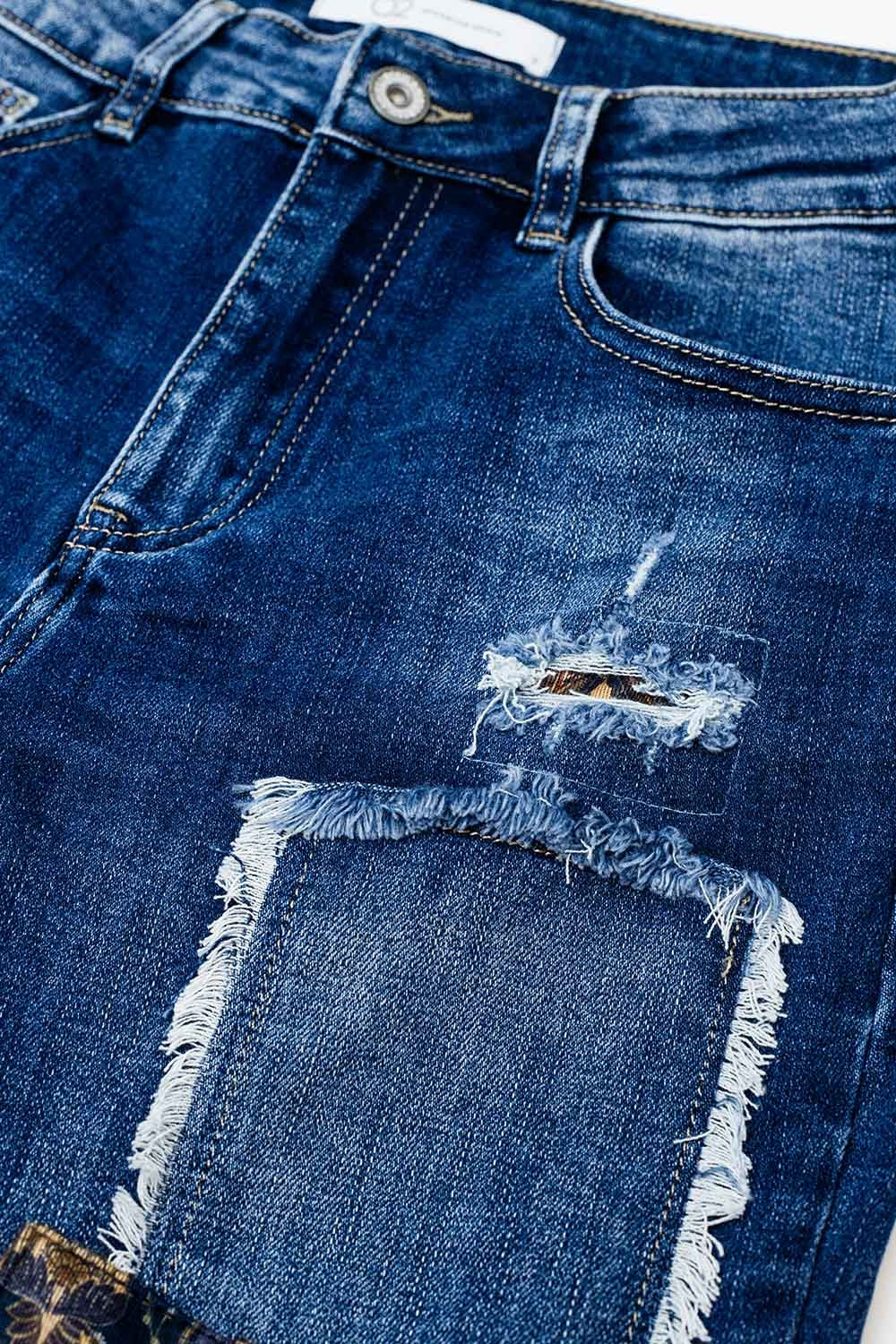Jean bleu ample avec un motif déchiré subtil et des patchs