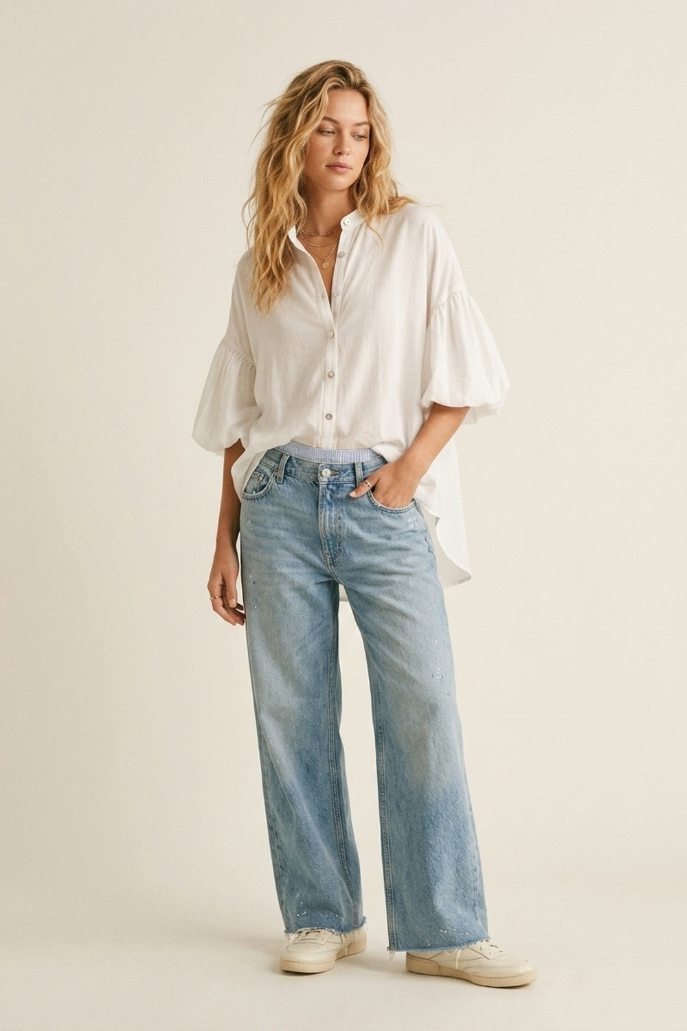 Blouse blanche à manches bouffantes avec ourlet asymétrique