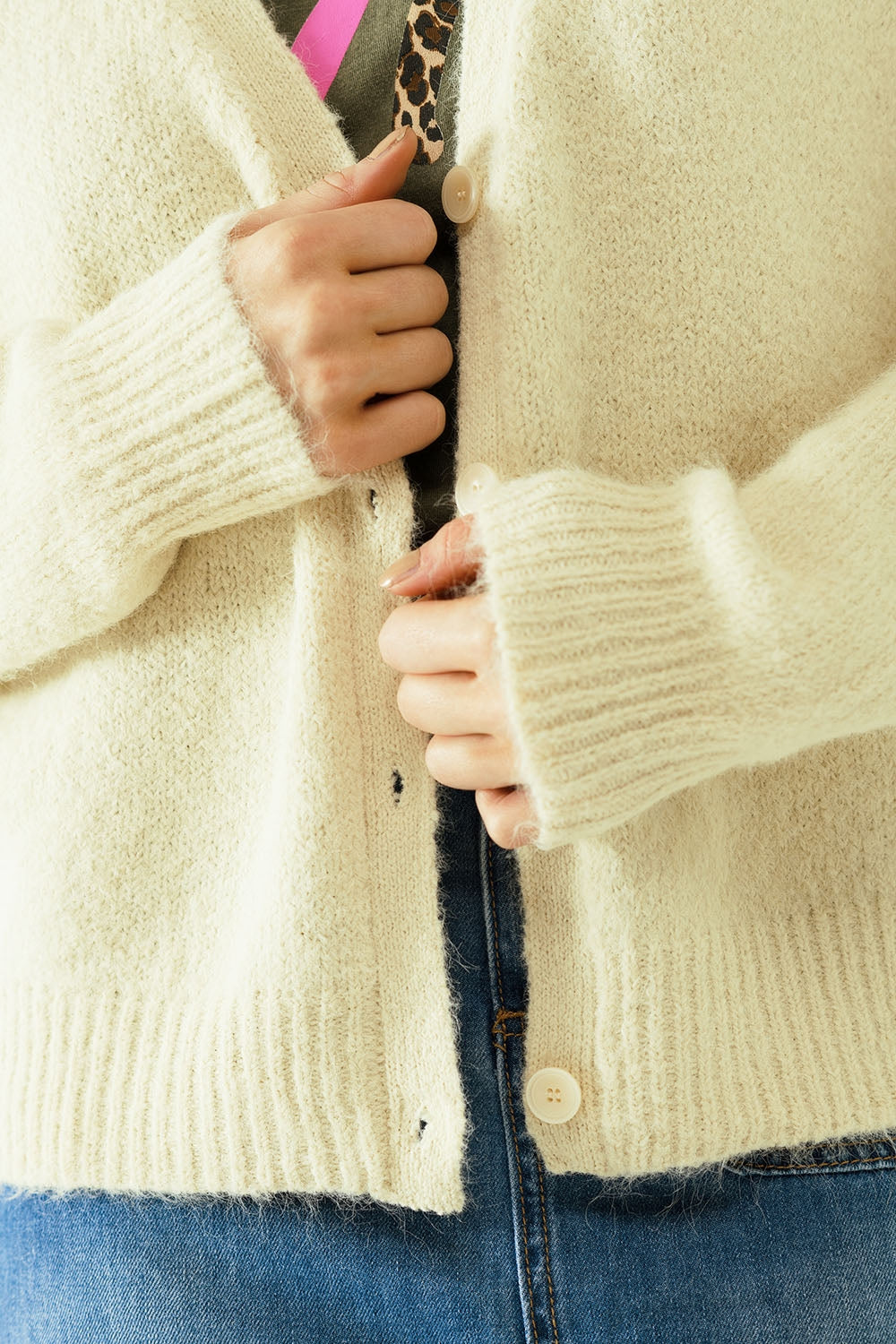 Cardigan à manches longues de couleur crème avec fermeture sur le devant par des boutons