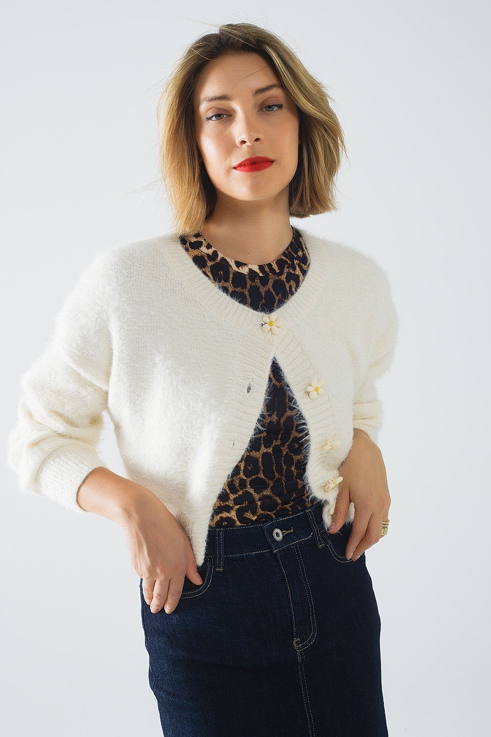 Cardigan court et moelleux de couleur crème avec des boutons en forme de fleurs