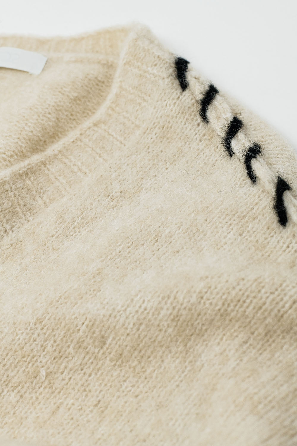 Cardigan ouvert crème avec bordure noire en maille épaisse