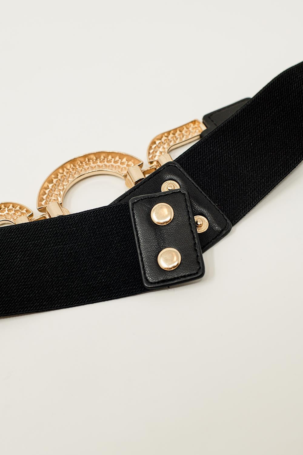 Ceinture élastique noire étroite avec incrustation de strass en cercle.