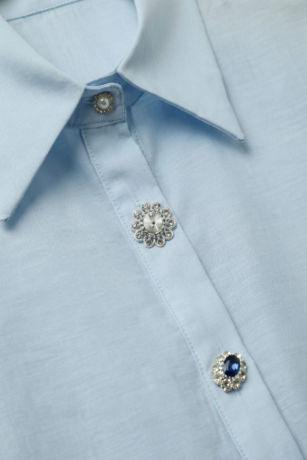 Chemise bleu clair en satin à manches longues avec deux boutons au poignet