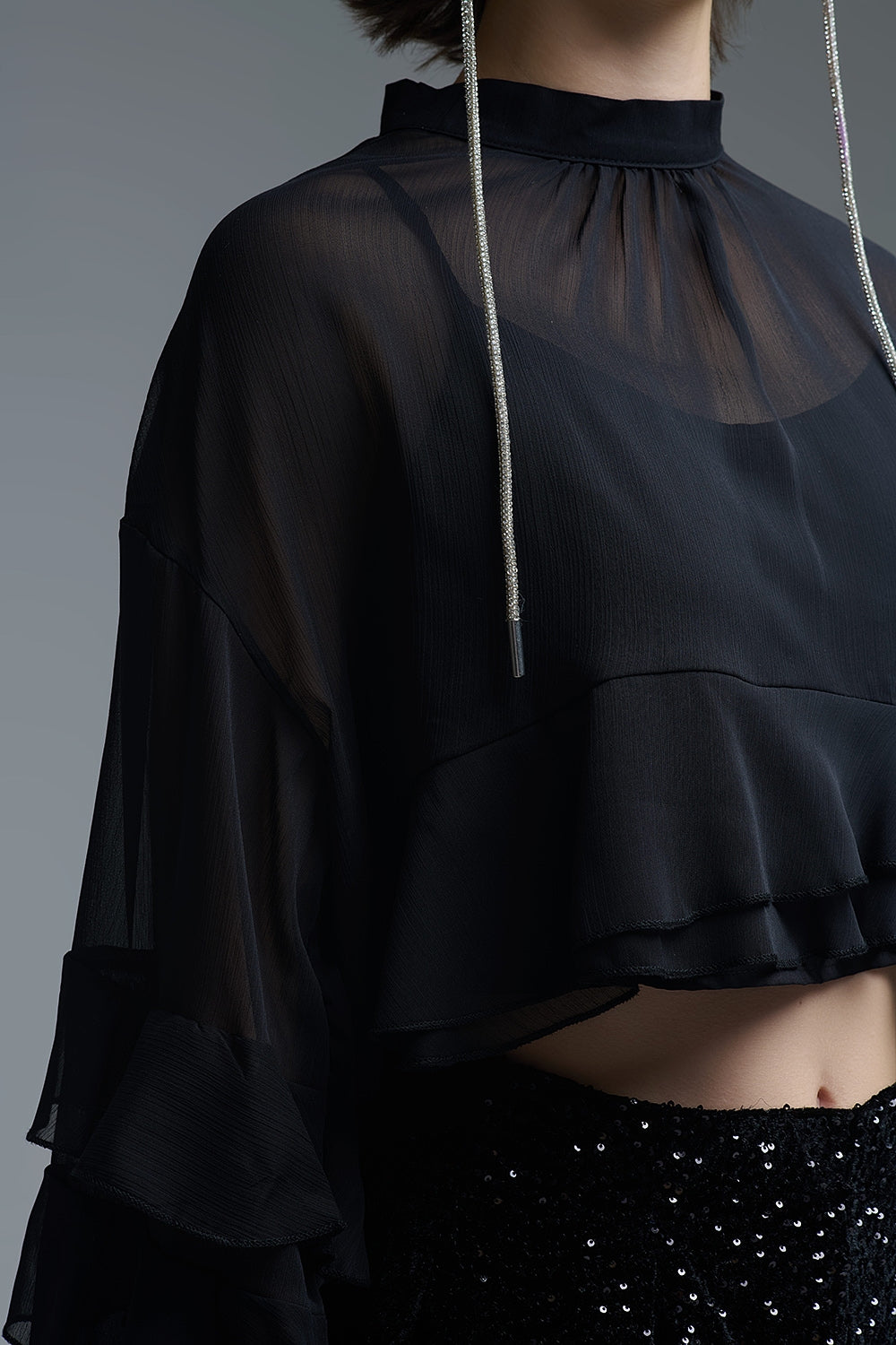 Chemisier noir à capuchon en mousseline de soie avec volants