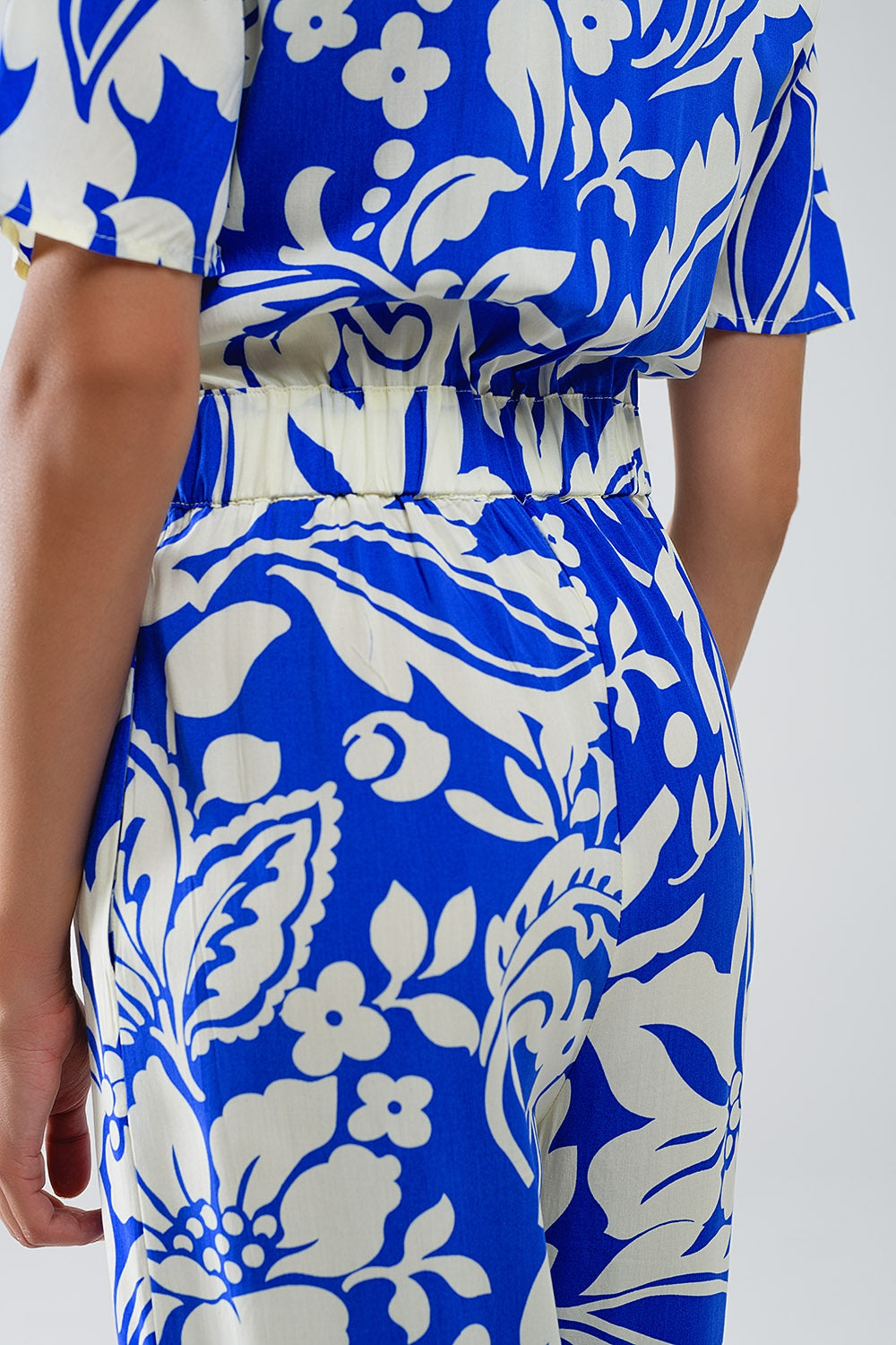 Combinaison à manches courtes avec trou de serrure sur le devant et motifs floraux en bleu