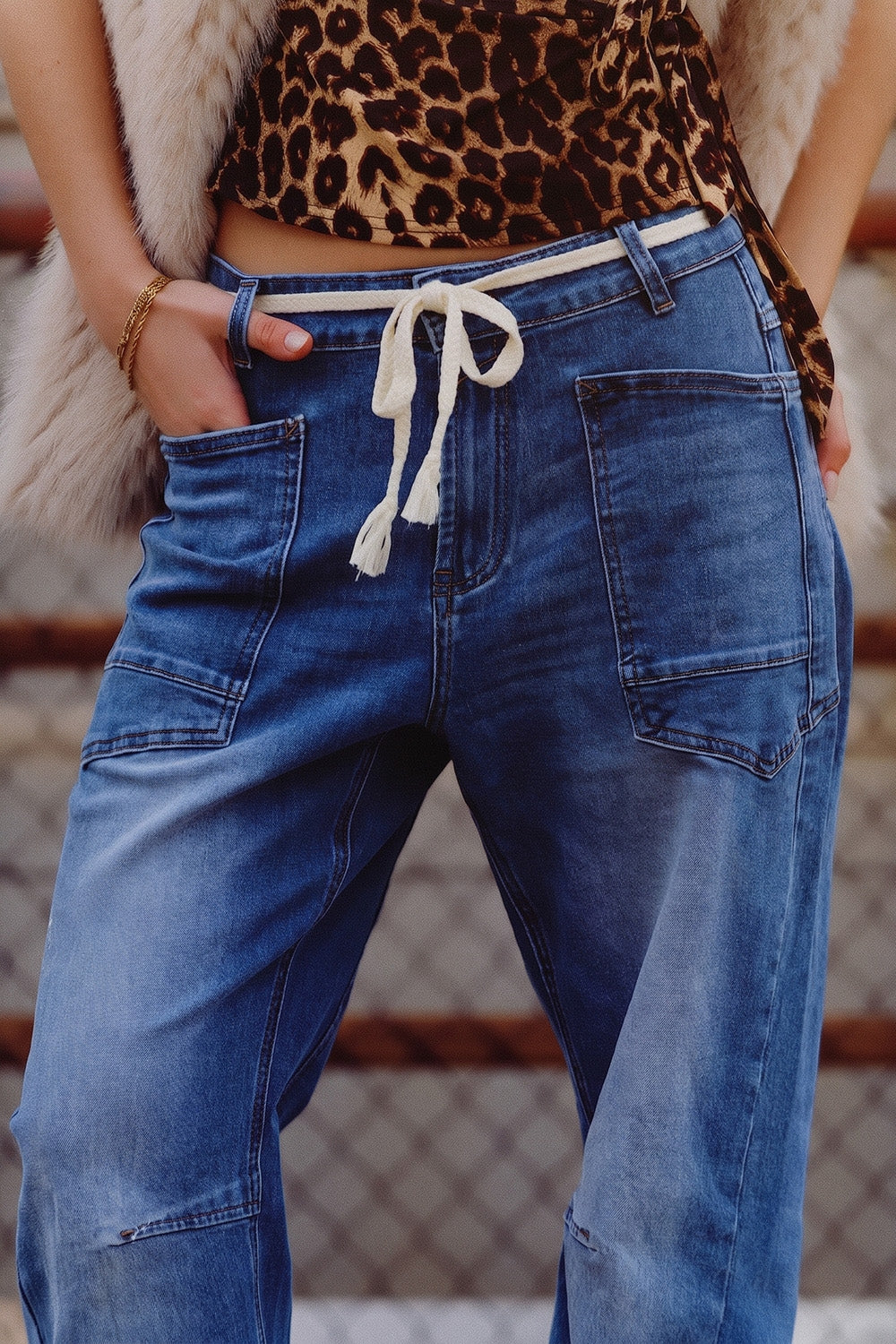 Jean bleu délavé moyen à jambes larges et ceinture.