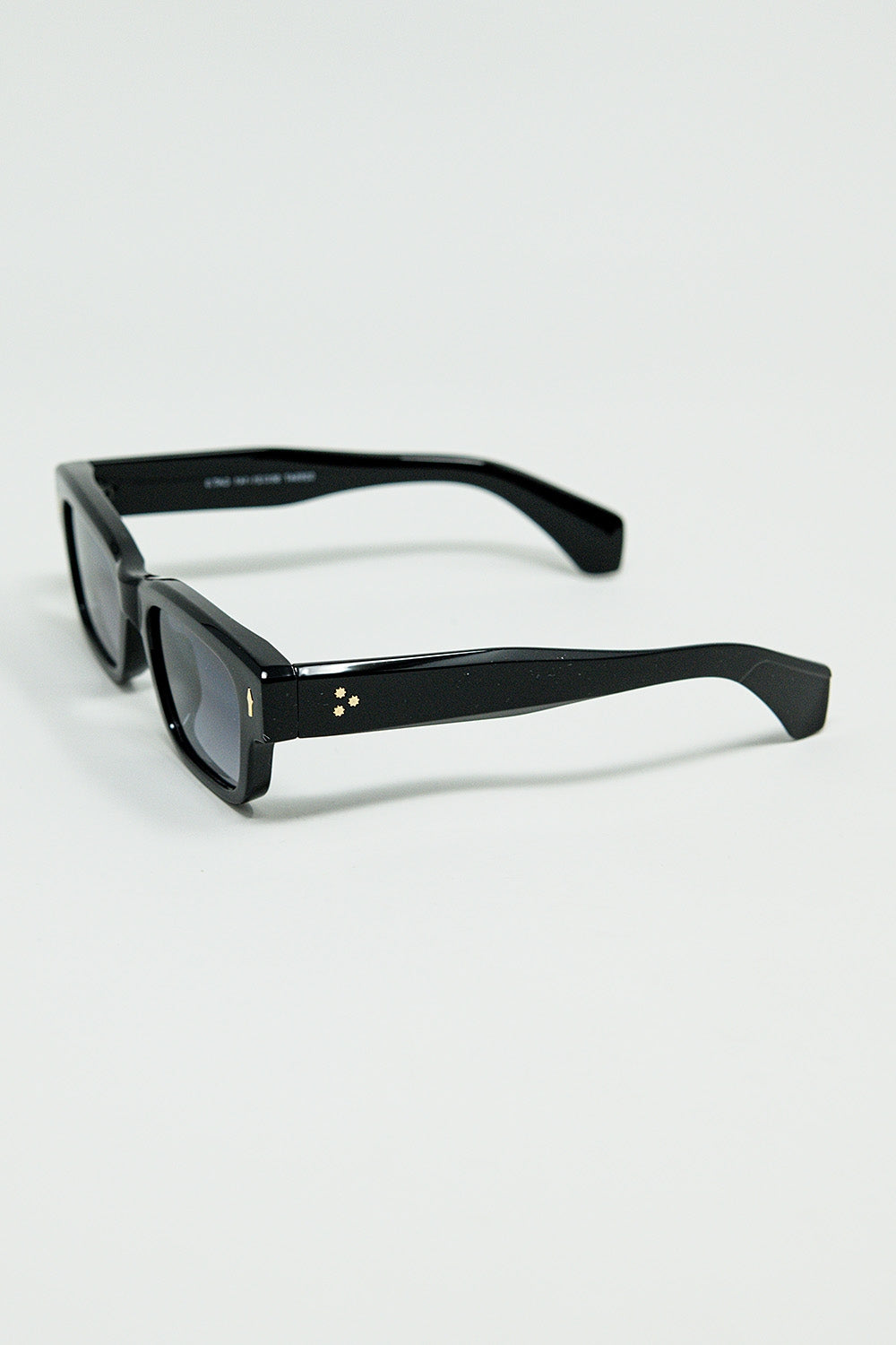 Lunettes de soleil noires à monture ovale avec détails dorés