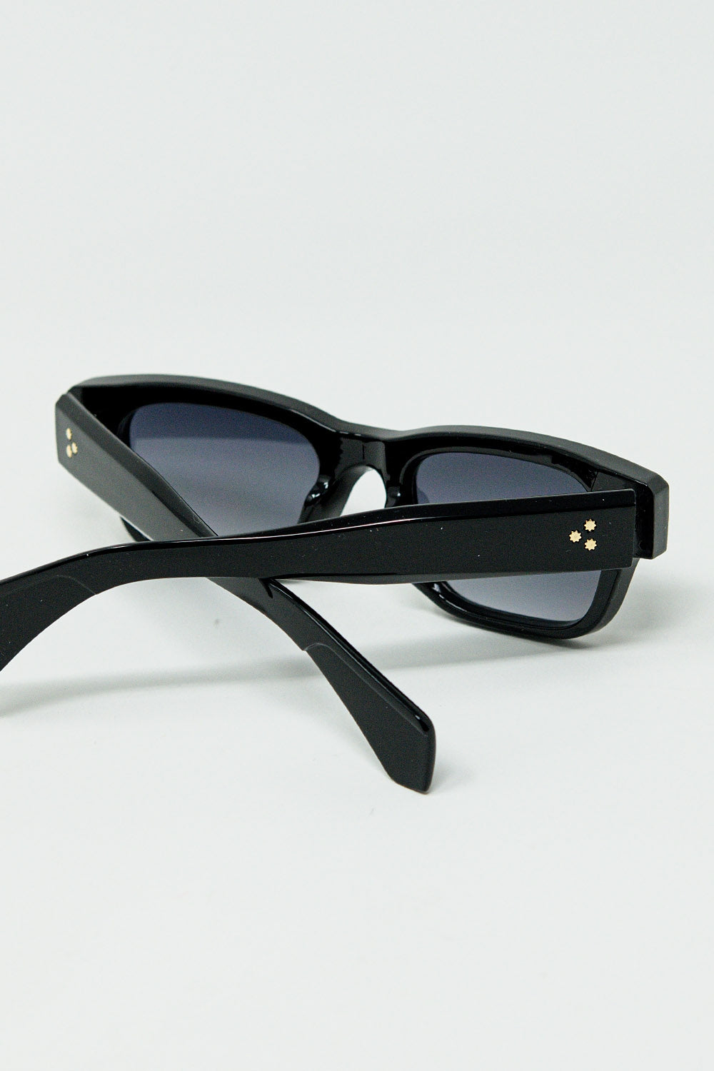 Lunettes de soleil noires à monture ovale avec détails dorés