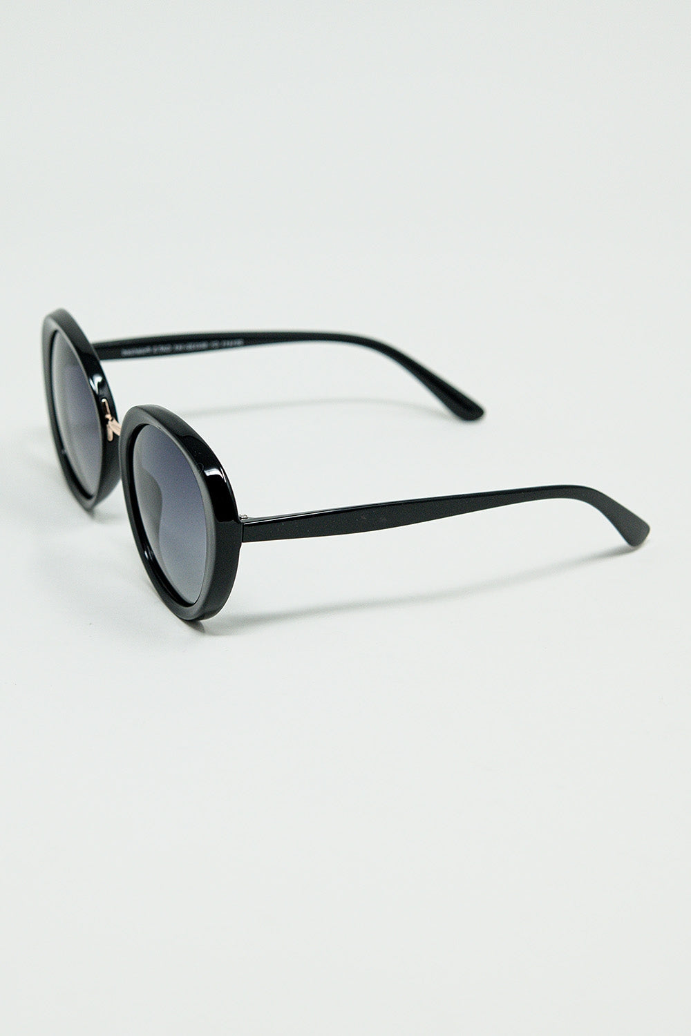 Lunettes de soleil noires de forme ovale avec détails en métal doré